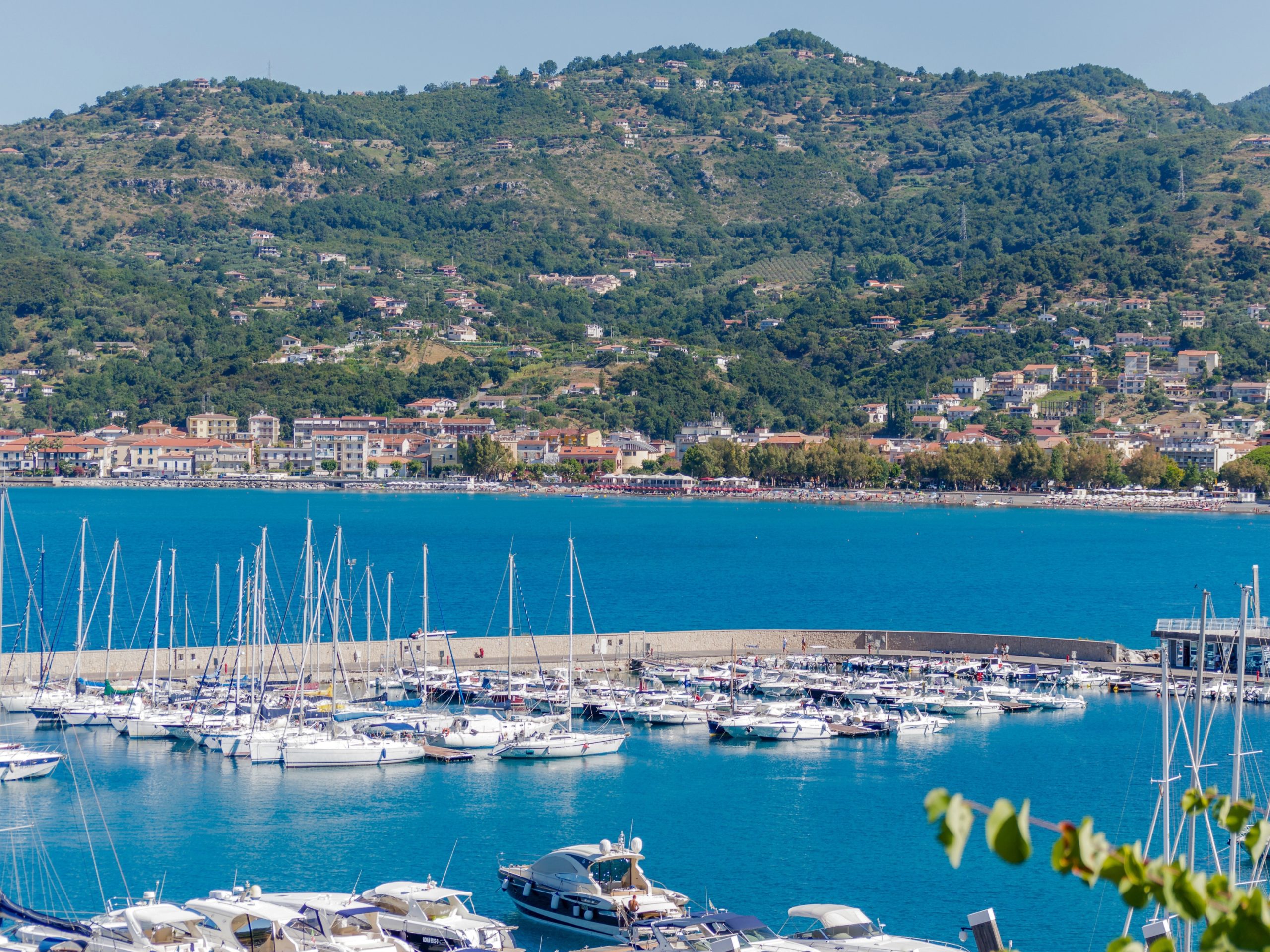 "Vista panoramica del porto di Sapri mare, con barche e monti del Golfo di Policastro in lontananza"
